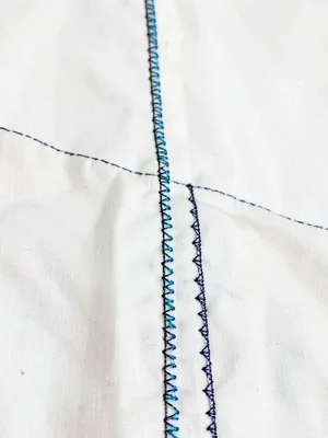 Side seam embroidery — narrow protective band running down garment side seam