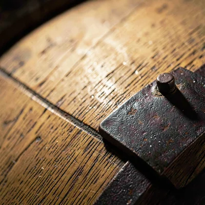 Mineral-cut macro of an oak barrel head with iron banding, raking light revealin
