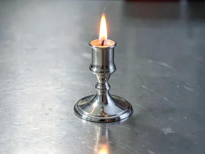 Silver candlestick reflecting flame