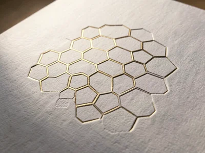 Blind embossed geometric hexagon grid on white cotton paper, raking sidelight re