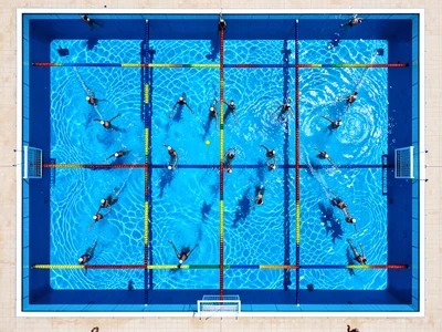 A water polo pool during a match viewed from above, the rectangular pool divided