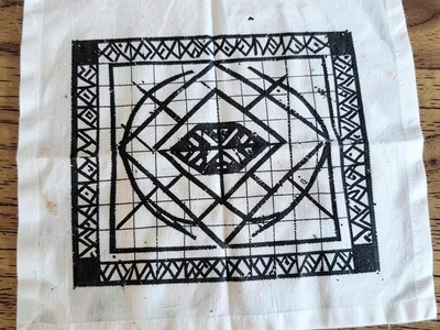 Mmusuyidee symbol stamped on white cotton — luck symbol in precise grid repetiti