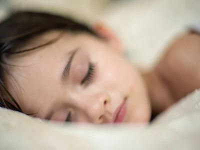 Sleeping child's eyelashes in perfect focus, rest of face and pillow and room so