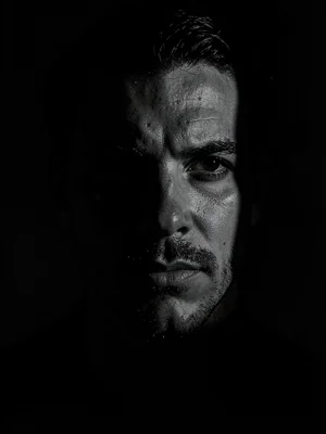 Half-face portrait emerging from shadow