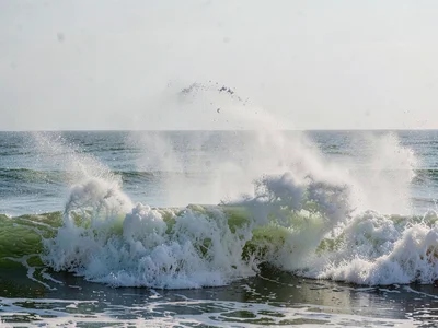 Wave impact creating spray cloud