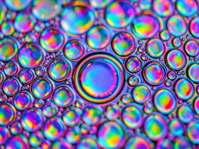 Sparse oil drops on water surface, widely spaced circles with dark gaps between,