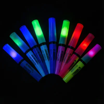 A set of fluorescent highlighter pens arranged in a fan, each ink color glowing 