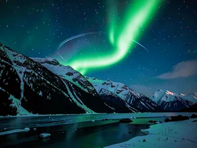 Aurora behind mountain ridge creating glow effect