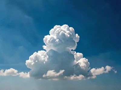 Single towering cumulus alone in otherwise empty blue field