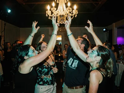 Dance floor at 2am, sweat on foreheads gone teal, overhead incandescent chandeli