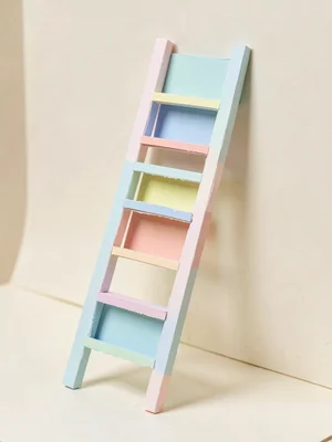 Towering ladder built from stacked pastel cards leaning against an invisible sup
