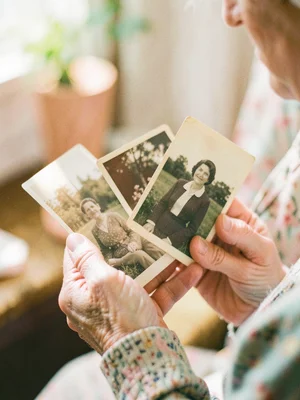 Grandmother's hands holding vintage photographs