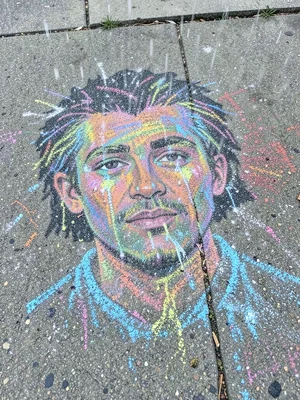 A chalk portrait being rained on: the face dissolving, colors running, the beaut
