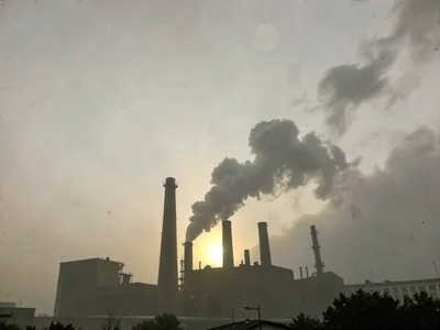 Factory silhouette against polluted sky