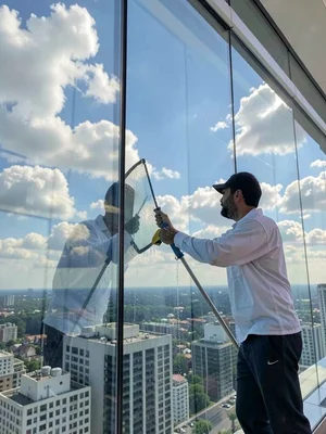 Window washer on high-rise reflected in the glass he's cleaning, floating in ref