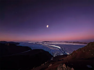 Venus visible against deep purple evening sky over glacier