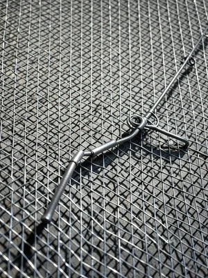 Wire sculpture of fishing rod and reel, delicate gauge, shadow on wall