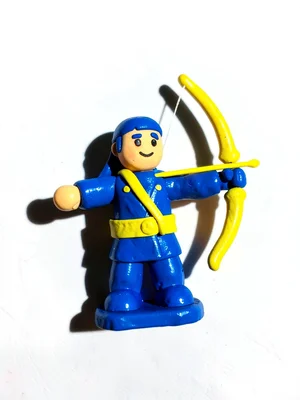 Stout clay archer miniature in cobalt and yellow with an oversized bow drawn bac