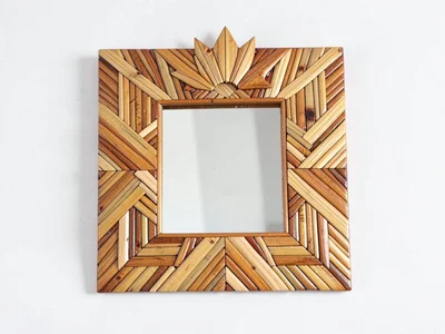 A small straw marquetry mirror frame with a sunray border, photographed flat