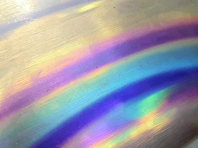 Tempered steel surface showing heat-treatment color gradient, straw gold fading 