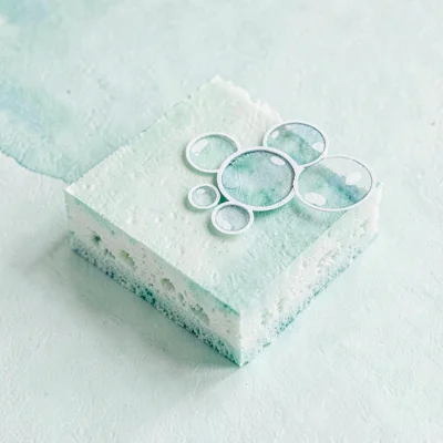 Papercraft icon of a folded paper sponge with cut-paper bubble cluster, pale min
