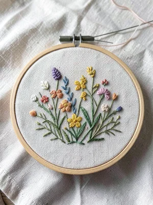 Embroidery hoop with half-finished spring garden, needle and thread visible