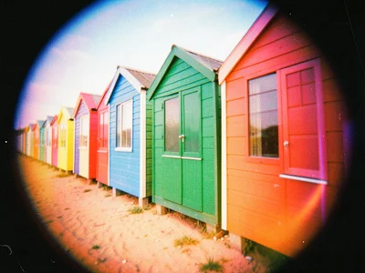 A row of colorful beach huts, each a different saturated color, the perspective 