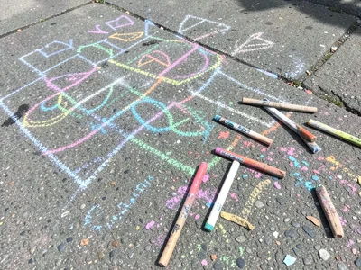 Colored chalk scattered beside a completed drawing, the sticks worn to different