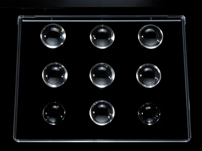 Transparent glass marbles on the scanner, each one catching and refracting the s