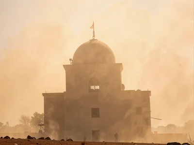 Building silhouette emerging from dense Harmattan dust at noon