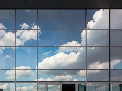 Reflected clouds moving across static facade