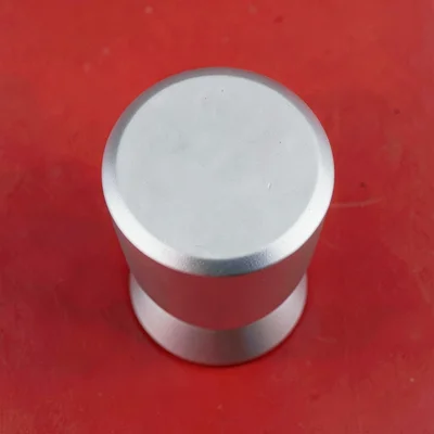 matte-finish single chrome cocktail-jigger top-down on a saturated tomato backdr