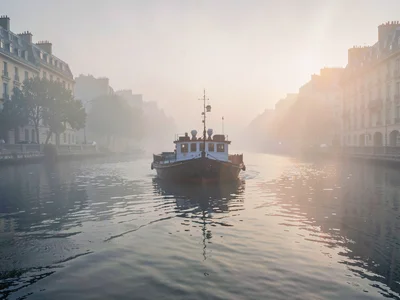 Barge emerging from fog on still morning
