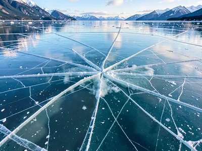 Cracks radiating through crystal-clear lake ice