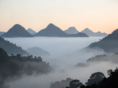 A mountain valley filled with fog, only the highest peaks visible as dark island