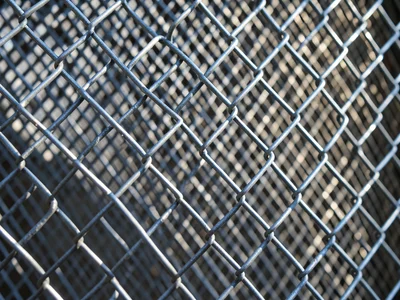 Chain link fence extreme closeup, diamond pattern of interlocking galvanized wir