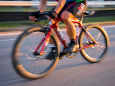 Cyclist racing past creating horizontal blur of wheels and pumping legs