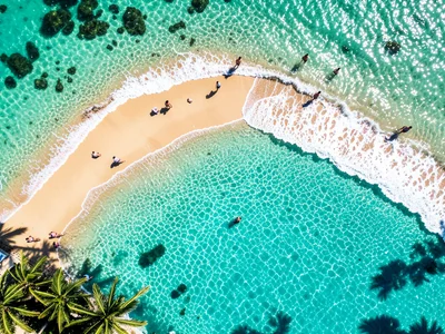 A beach scene from high above: the shoreline as a curve, turquoise water, white 