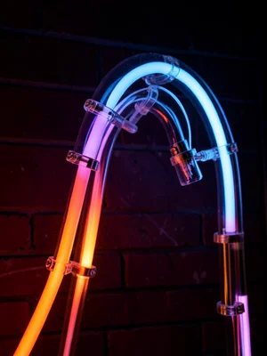 A blue mercury-vapor tube bent into a sweeping curve, phosphor coating visible i
