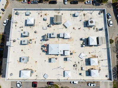 Strip mall rooftops, HVAC units and skylights in repetitive rhythm