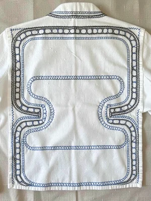 Back panel of Ainu coat — embroidery bands framing plain white back field