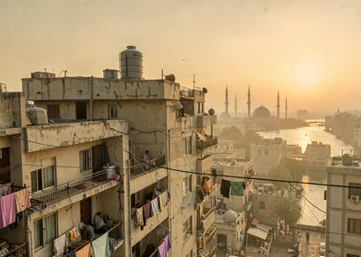 Dusty golden Cairo haze compressing apartment layers, water tank on rooftop, sky