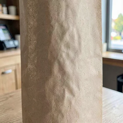 Vertical paper texture of a long roll of brown wrapping paper at the till