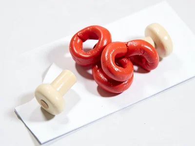 Whippy chunky clay jump rope in cherry red with stubby cream-toned wooden-toned