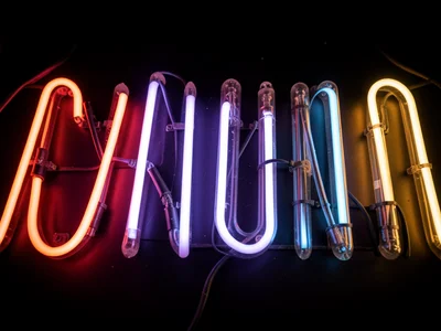 A vintage neon sign with some letters dead: the lit tubes and dark tubes creatin