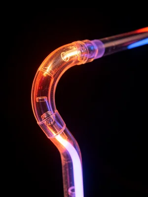 A single neon tube making a tight bend, the glass stressed at the curve, the gas
