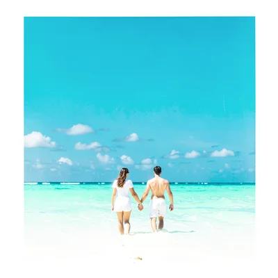 Expansive turquoise negative space, bleached whites, Two people holding hands wa