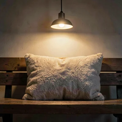 Cozy atmospheric of a soft cushion on a wooden bench, single warm pendant castin