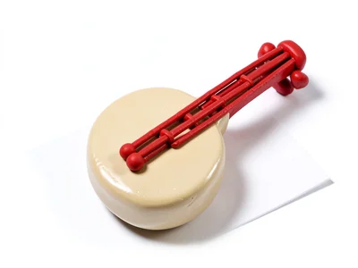 Bowed chunky clay banjo in cream-tan with stubby cherry-red squat strings and ov
