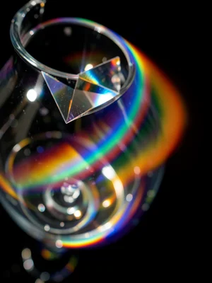 Spectral light band bending around a curved glass vessel, rainbow wrapping the c